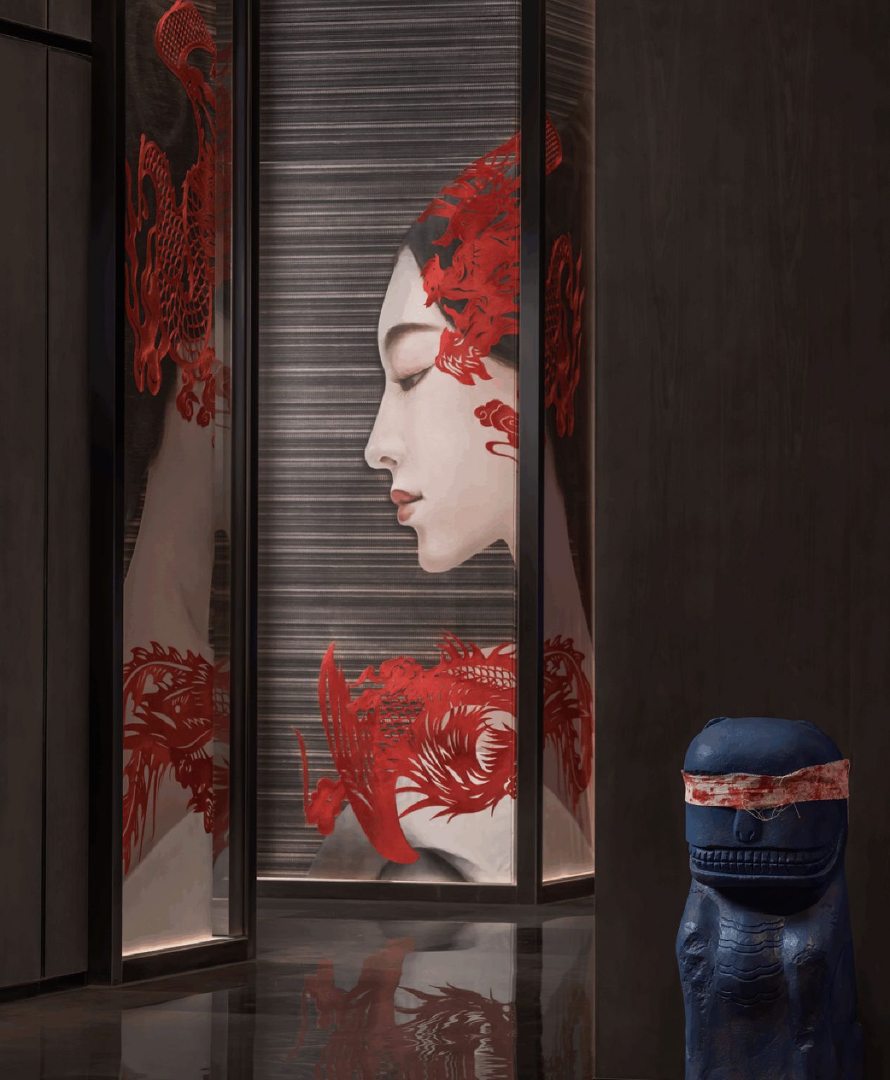 Large wall artwork of a woman’s profile with red dragon motifs, paired with a blue sculptural figure wearing a red blindfold at Park Hyatt Suzhou.