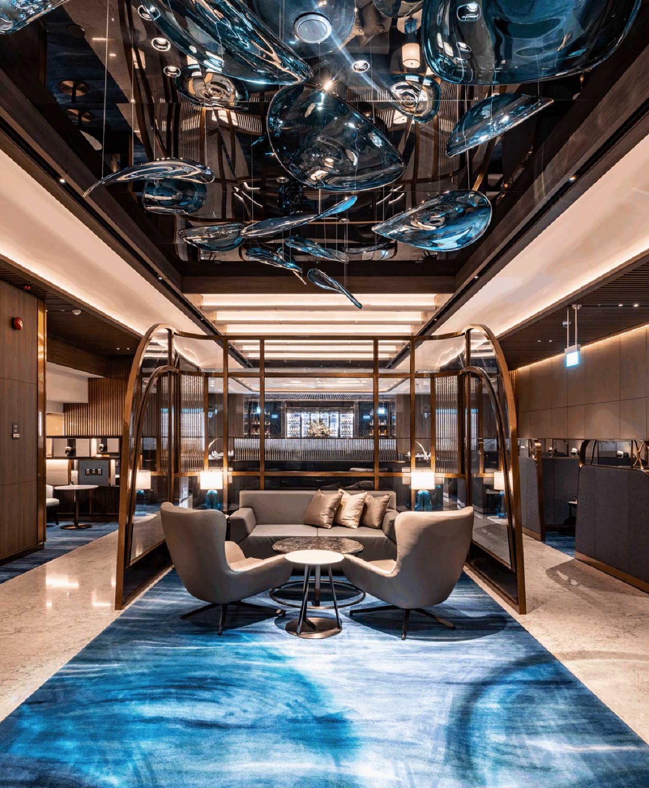 A cozy airline lounge area with modern seating, elegant decor, and artistic ceiling installations, creating an inviting and sophisticated atmosphere for relaxation.