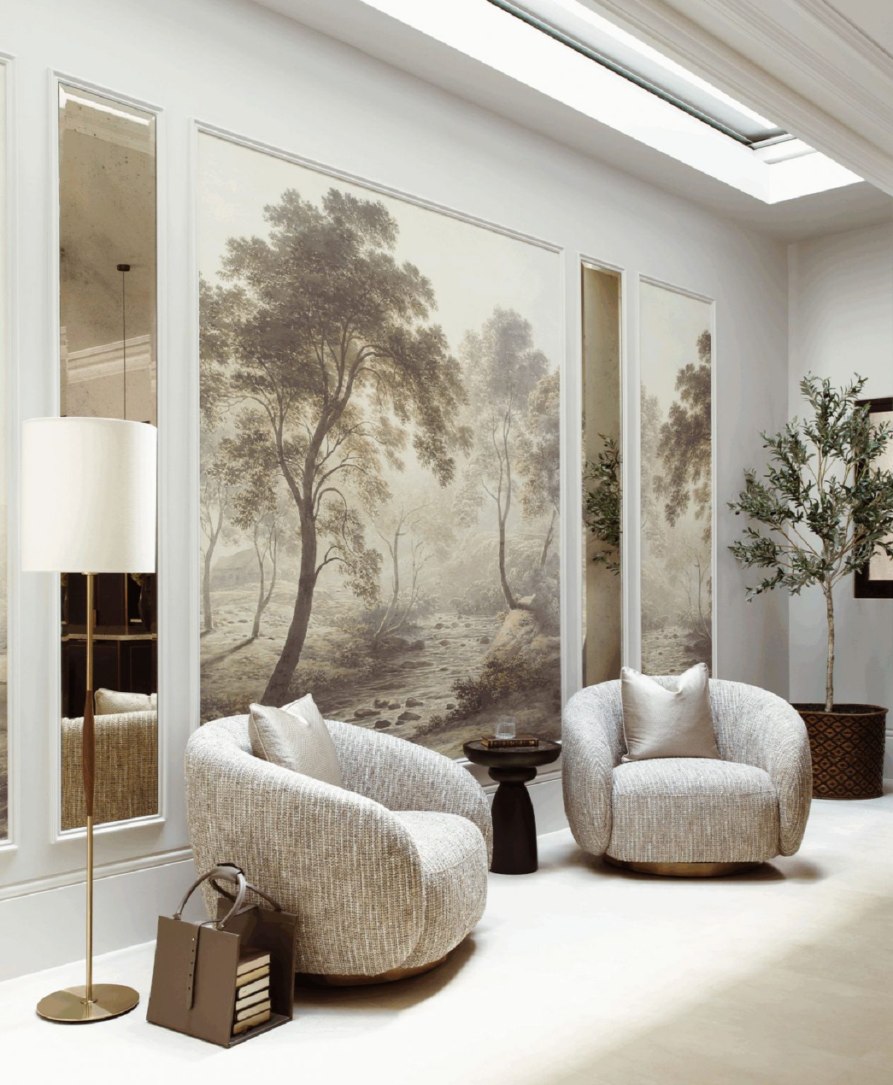 Luxurious lounge with two textured armchairs, a floor lamp, and a soft landscape mural depicting trees and a stream. Cozy, elegant ambiance.